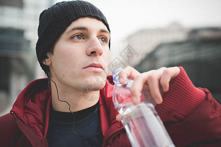 拿着水杯喝水的男青年图片