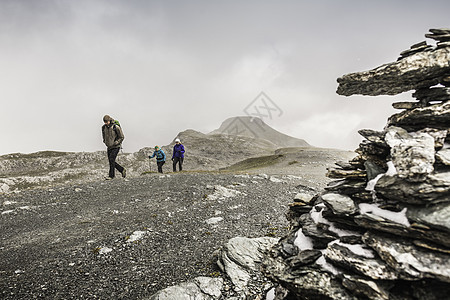 瑞士男女旅行者们在荒凉的土地上徒步旅行图片