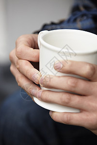 拿着咖啡杯的年轻男子手图片