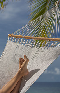 年轻女士在热带岛屿的吊床上放松图片