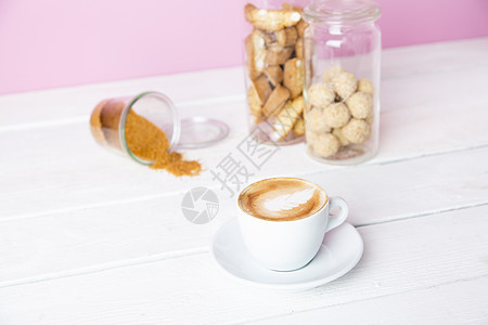 一杯咖啡和饼干罐的静物画图片