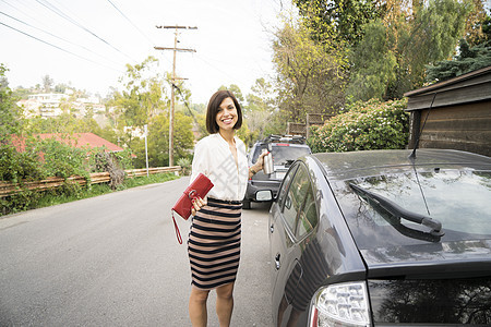 在郊区街上汽车旁边的职业女性
图片