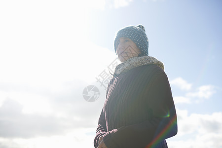蓝天下穿着毛衣戴着帽子的成年女子图片