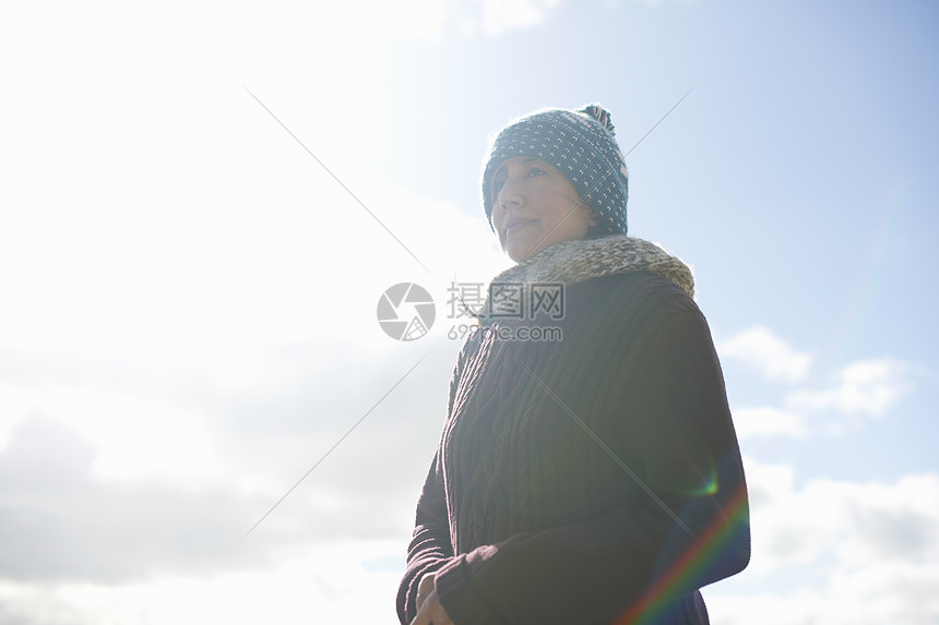 蓝天下穿着毛衣戴着帽子的成年女子图片