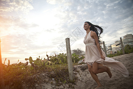 成年中妇女沿着沙道向海滩跑去图片