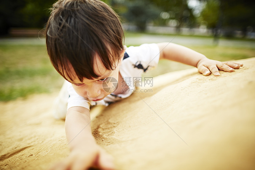 男孩在沙地上爬行图片