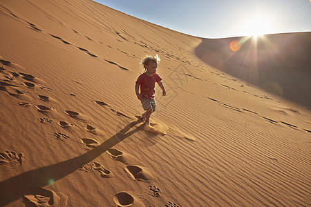 男孩在沙丘上奔跑图片