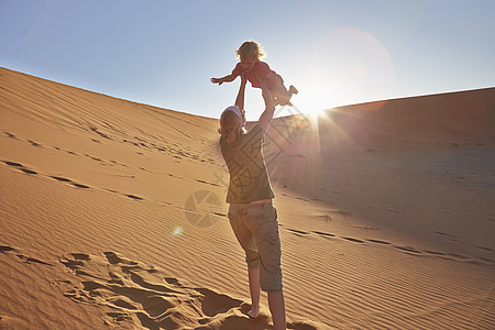 母亲与儿子在沙丘上玩耍图片