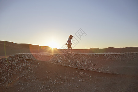 男孩在沙丘上行走图片