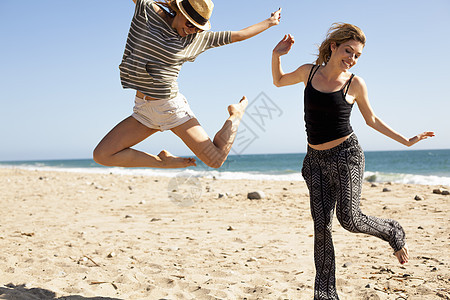 海滩上跳跃的两个人图片