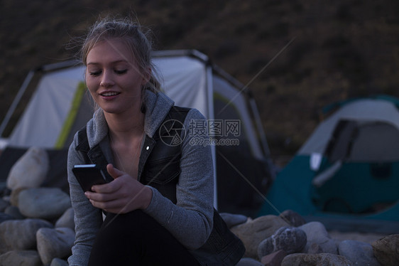 海滩上玩手机的女人图片