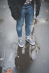 年轻女孩站在湿漉漉的马路上图片