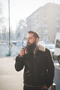 长胡子的年轻人在街上抽烟图片