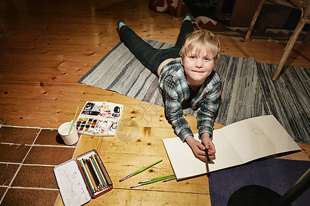 男孩躺在地板上画水彩画图片