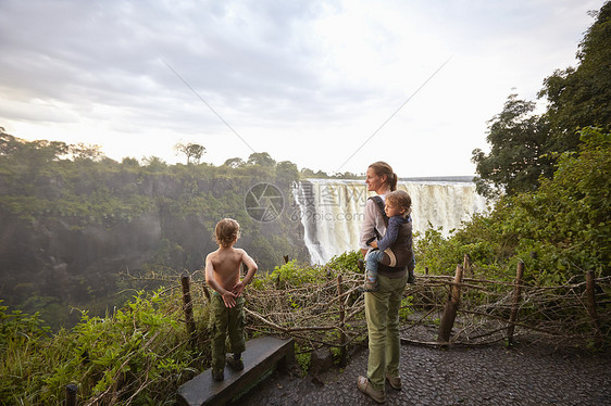 站在瀑布前欣赏风景的母亲和孩子图片