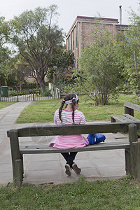 坐在长椅上的年轻女孩图片