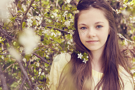 开花的树枝旁漂亮女孩的肖像图片