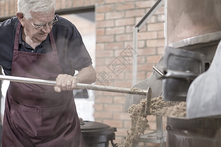 中老年男性清洗酿酒厂铜水壶图片