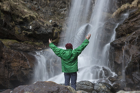 男青年站在瀑布前的背影图片