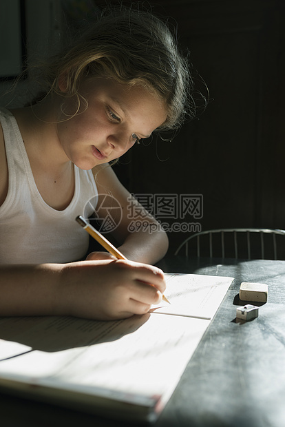 女孩使用笔和本子做功课图片