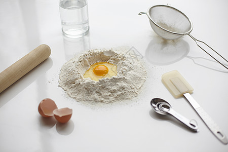 面粉堆和厨房用具中间生蛋烤制图片