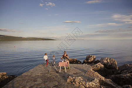 母亲和两个儿子在克罗地亚尔海岸野餐图片