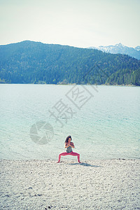在湖边练习瑜伽的女性图片