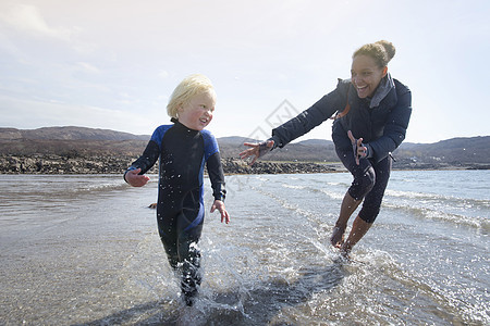 母亲和儿子在苏格兰的海滩上奔跑图片