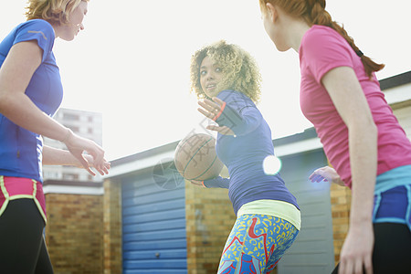 三名妇女一起打篮球的肖像图片