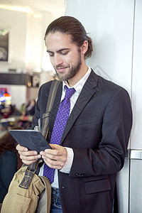 车站拿着平板电脑进行办公的商务男士图片