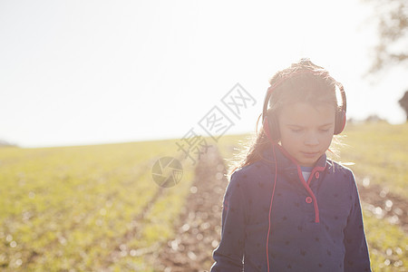 穿戴耳机在野外散步的女孩图片