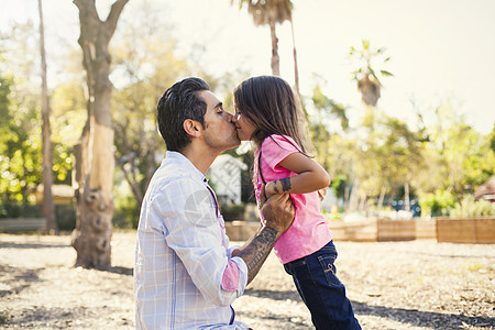 在社区花园亲吻父亲的女孩图片