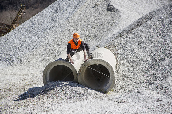 在采石场测量工业管道的采石人图片