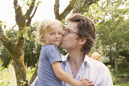 成熟男人的肖像亲吻在花园里的脸颊上儿子图片