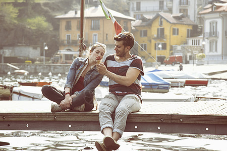 坐在码头边吃冰淇淋的一对夫妇图片