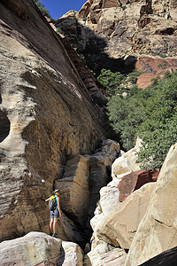 美国内华达州威尔逊山站在巨石上向外眺望的年轻女攀岩者图片