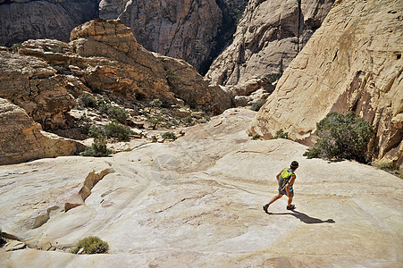 在山岩石上徒步旅行的年轻女远足者图片