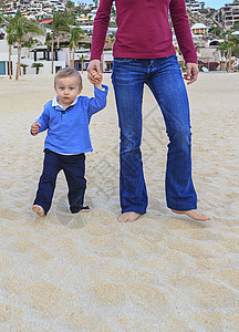母亲和儿子在沙滩上手牵低档图片