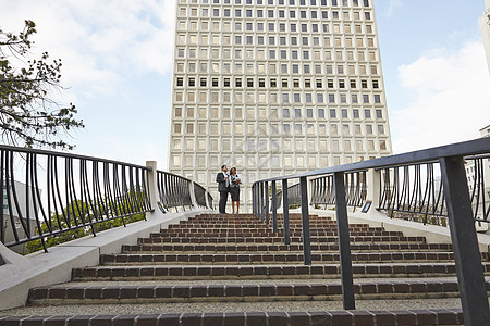 美国加利福尼亚州洛杉矶市政厅东商务人士站在楼梯顶部的低角度视图图片