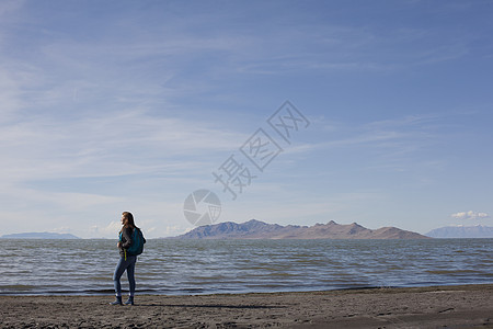 美国犹他州大盐湖站在水边向外眺望的年轻女子的后视图图片