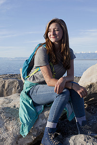 年轻女孩坐在岩石上看向盐湖远方图片