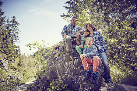 坐在森林岩石上的家庭肖像图片