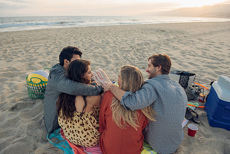 一群朋友在海滩上野餐背影图片