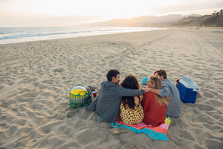 一群朋友在海滩上野餐背影图片