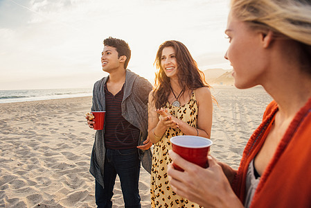 一群朋友在海滩上喝酒日落图片