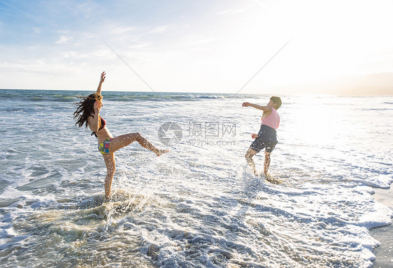 海滩上的小情侣在海上玩耍图片