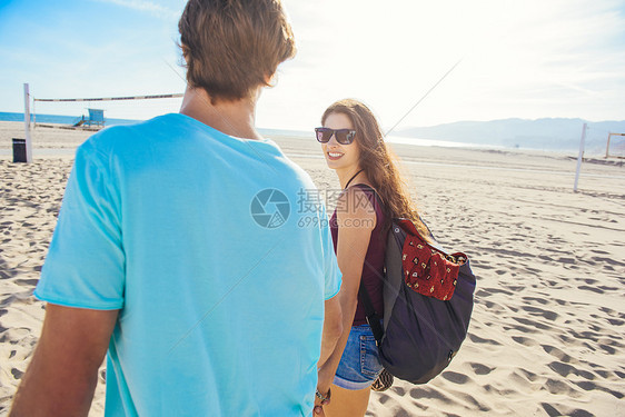 年轻夫妇在海滩上行走后视图片
