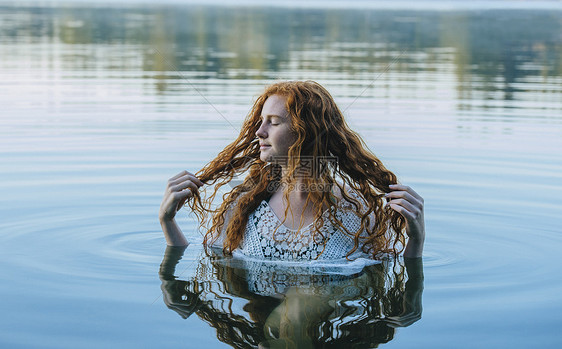 半身浸入湖水的年轻女性形象图片