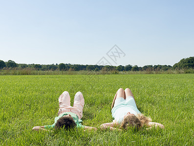 男孩和女孩平躺在草地上看着天空图片