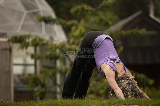 在生态小屋花园里做瑜伽的成年女子图片